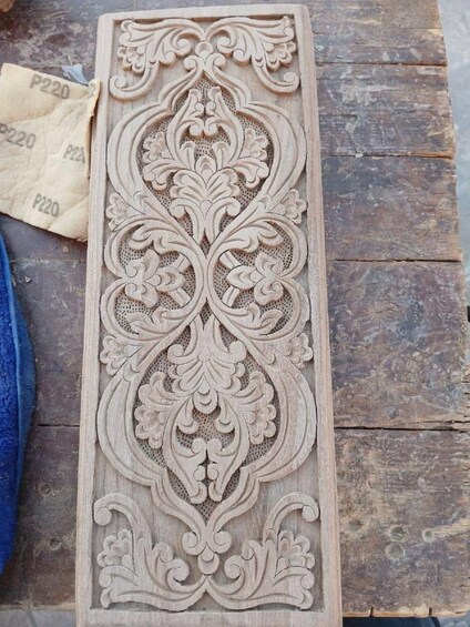 Ein detailliert geschnitztes Holzpaneel mit aufwendlichen floralen und geschwungenen Ornamenten. 3