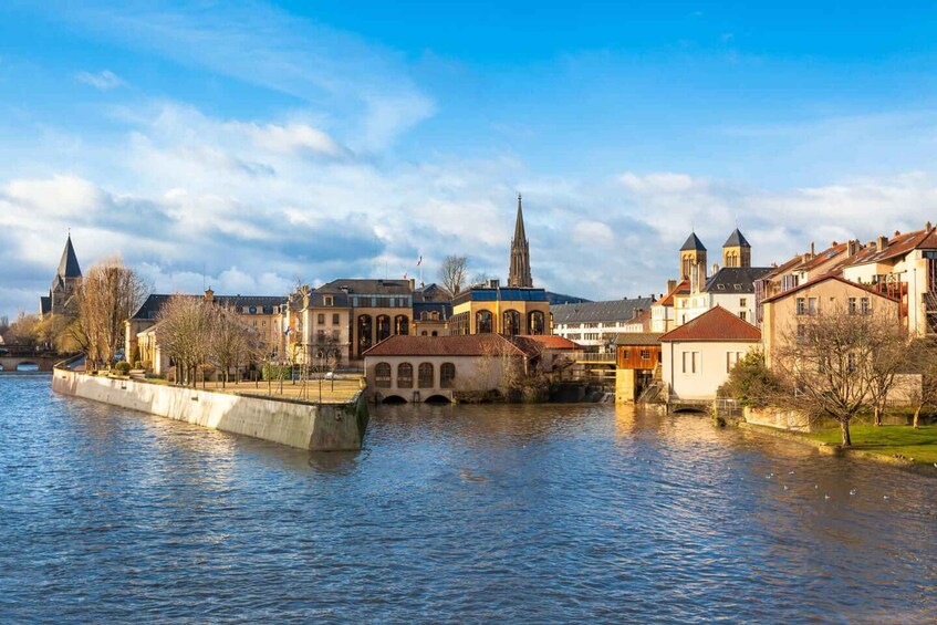 A riverside town with historic buildings, a church, and a bridge. 3
