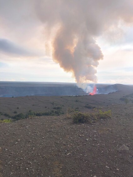 A landscape with a large plume of smoke and a small fire. 5