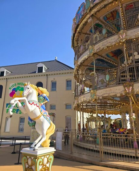 En karrusel med dekorativ udsmykning og en hvid heste statue foran. 5