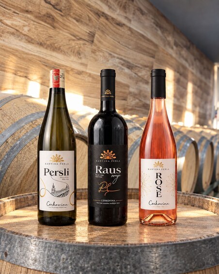 Three wine bottles on a wooden barrel with a wooden background. 4