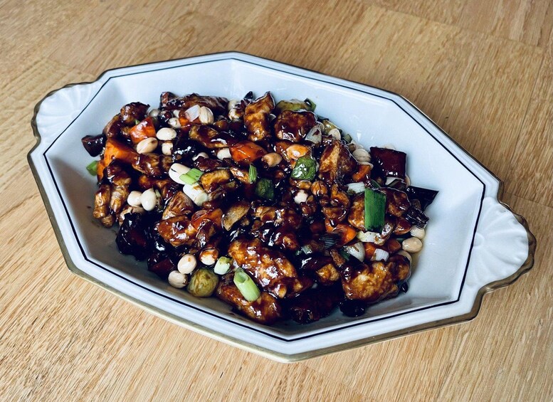 A dish of stir-fried vegetables and meat in a white bowl. 1