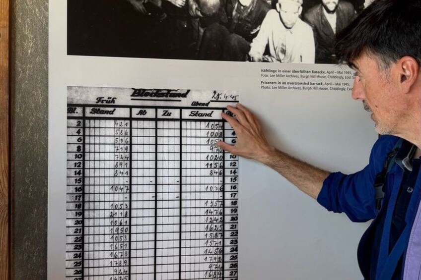 A man pointing at a table with rows and columns of numbers. 3