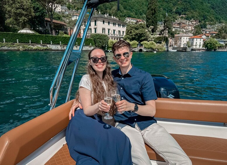 Two people on a boat with a lake and buildings in the background. 3