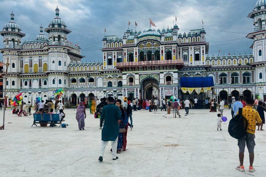A large, ornate building with domes and arches, surrounded by a crowd of people. 4