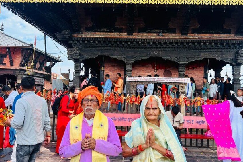 A temple with a crowd of people, traditional attire, and a decorated entrance. 5