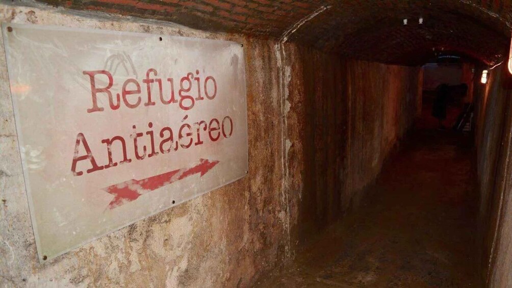 Une pancarte dans un tunnel indiquant « Refuge antiaérien » avec une flèche pointant vers la droite. 1