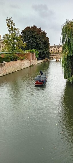 Un canal étroit, un pont, une rangée d’arbres et un bâtiment en arrière-plan. 5
