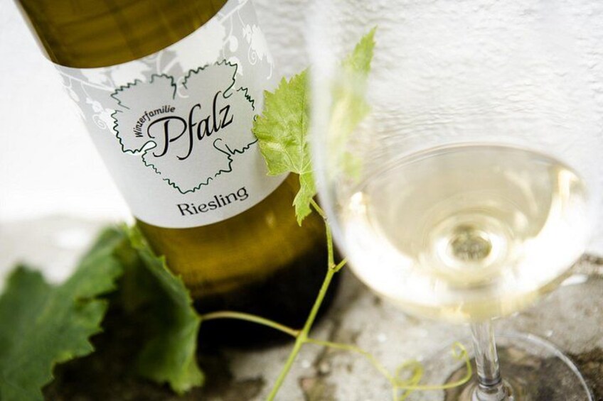 A bottle of Pfalz Riesling wine with a glass of white wine beside it. 4