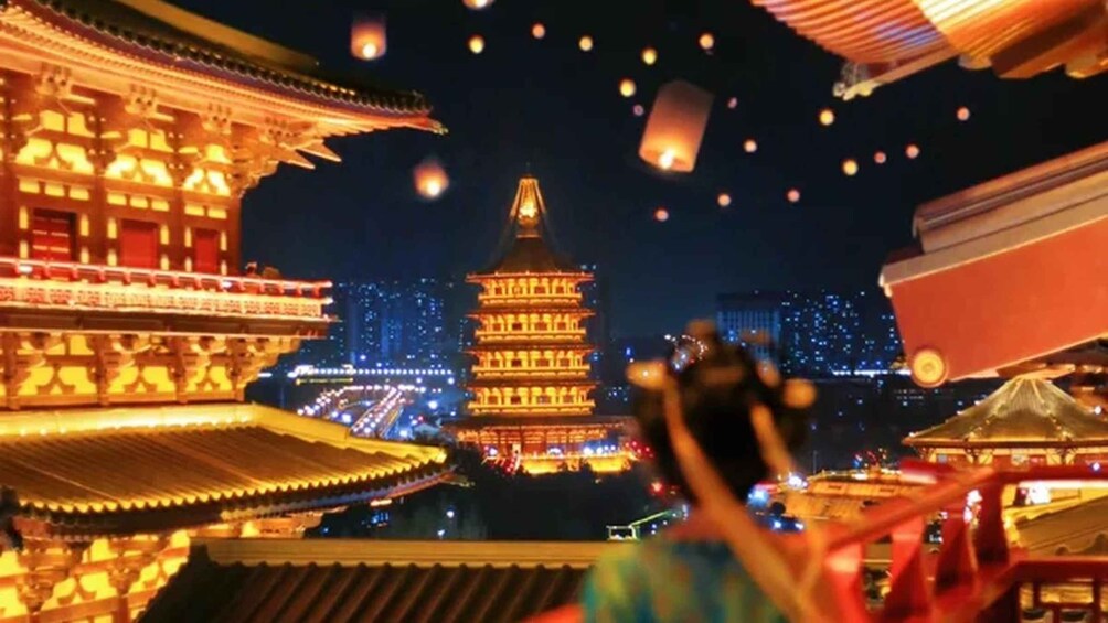 A night scene with illuminated traditional architecture and floating lanterns. 1