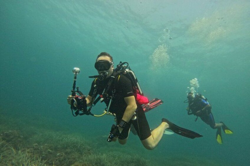 Two scuba divers underwater with fins and tanks. 3