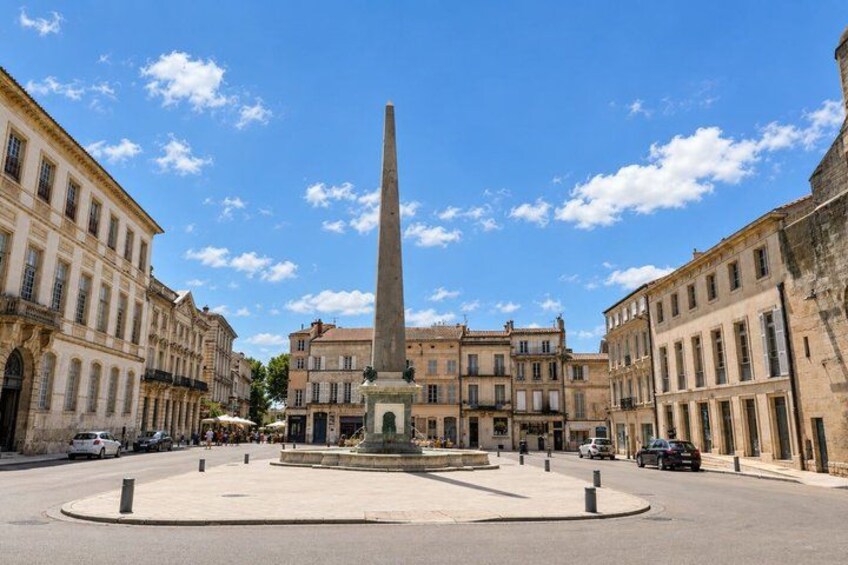 A central obelisk in a square surrounded by historic buildings. 5