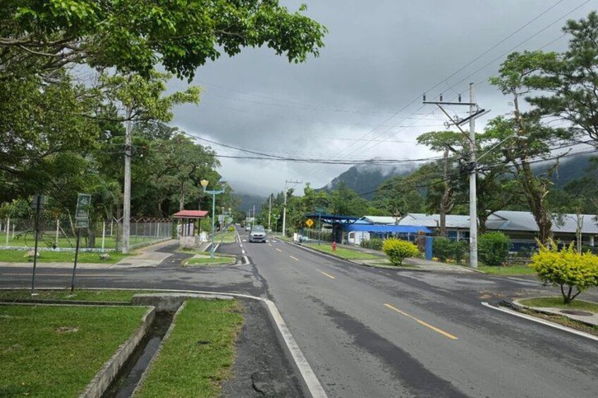 A road with a blue building and a red structure in the distance. 5
