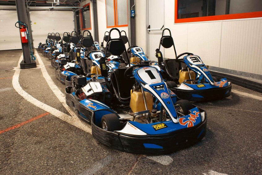 A row of go-karts lined up in a garage. 2