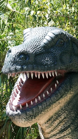 A dinosaur head sculpture surrounded by greenery. 3