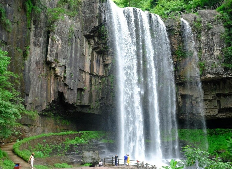 A waterfall cascading down a rocky cliff surrounded by lush greenery. 3