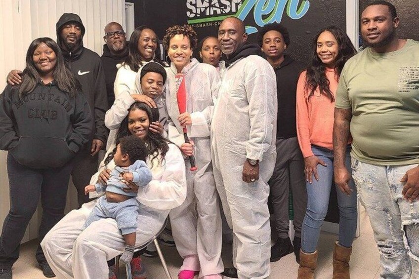 A group of people in a room with a sign that reads 'SMASH'. 2