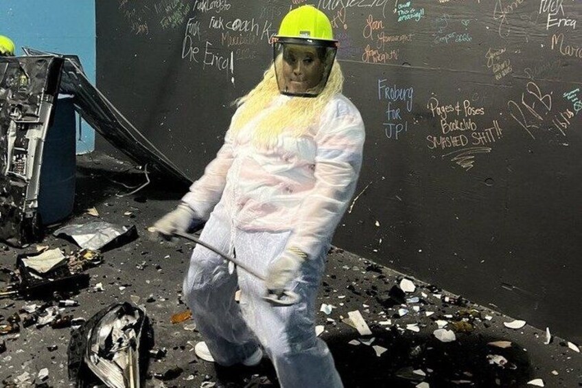 A person in protective gear cleaning a blackboard with writing on it. 5