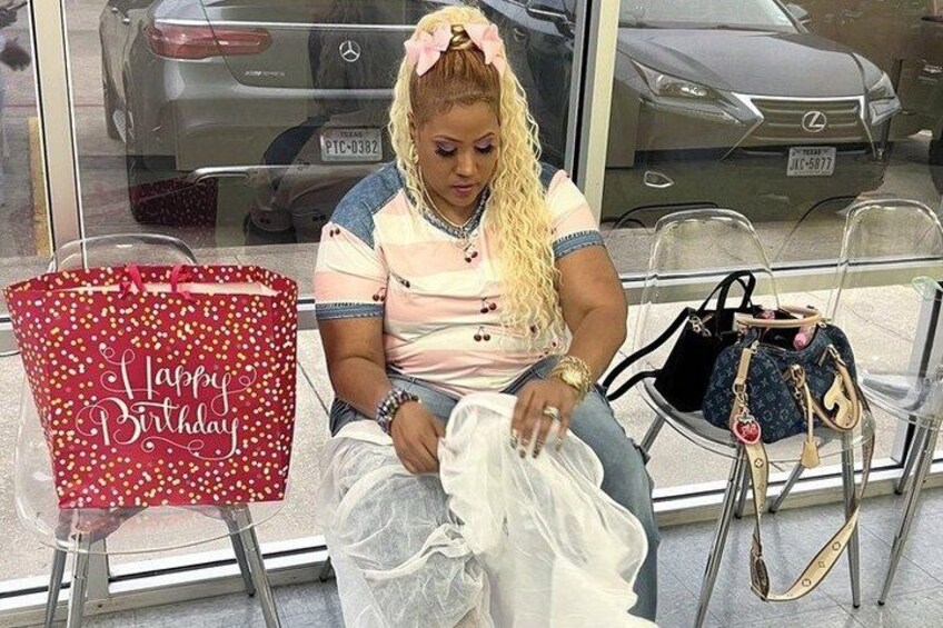 A person sitting on a chair with a red bag labeled 'Happy Birthday' and a handbag on the floor. 3