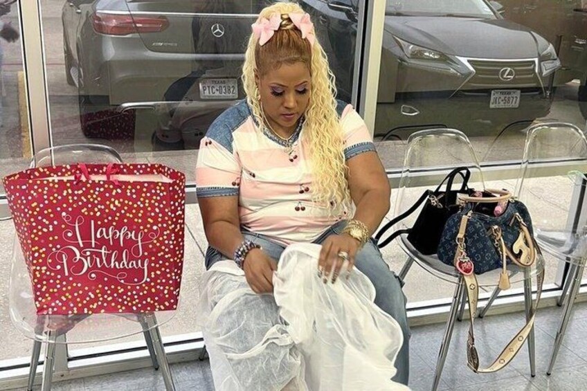 A person sitting on a chair with a red gift bag labeled 'Happy Birthday' and a handbag. 5