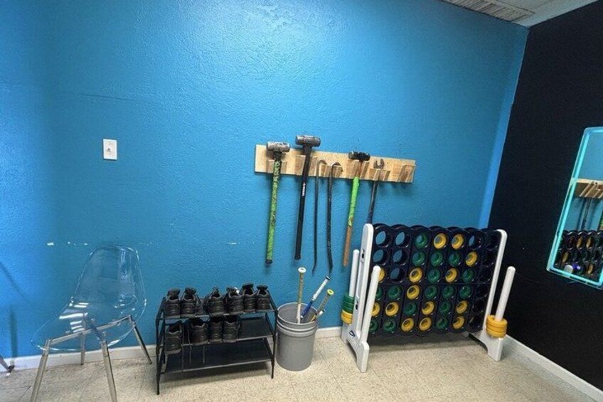 A room with blue walls, a shoe rack, a bucket, and a wall-mounted tool rack. 2