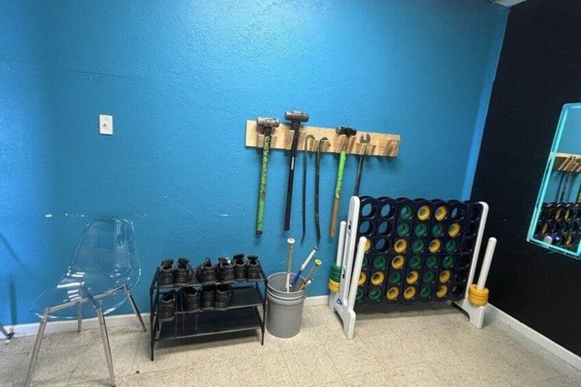 A blue wall with tools, a shoe rack, and a chair. 1