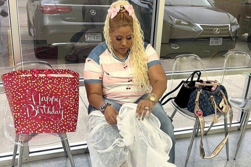 A person sitting on a chair with a red gift bag and a white plastic bag. 5