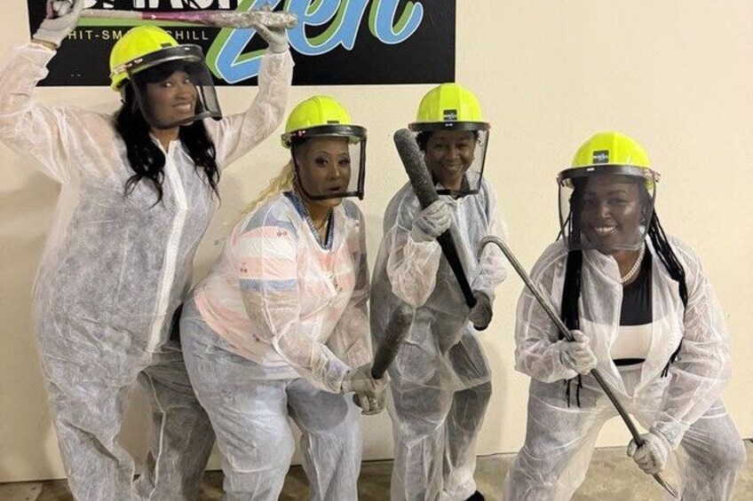 Four people in protective suits and helmets, posing with cleaning tools. 2