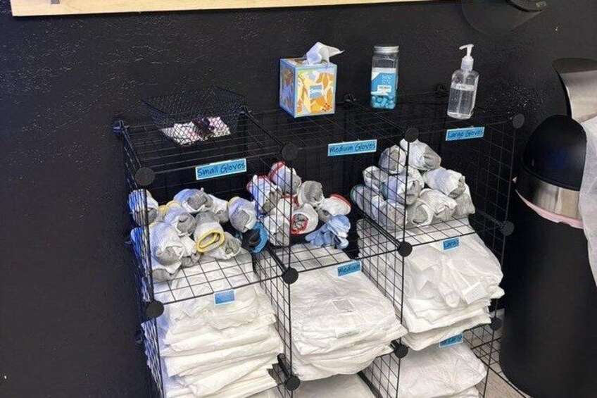 A storage area with labeled bins containing various items like gloves, masks, and tissues. 2