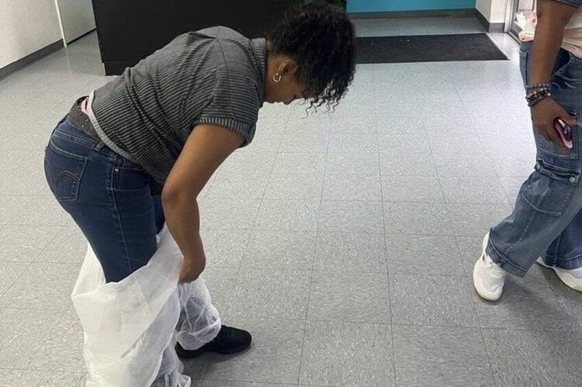 A person bending over, possibly tying or adjusting something on the floor. 3