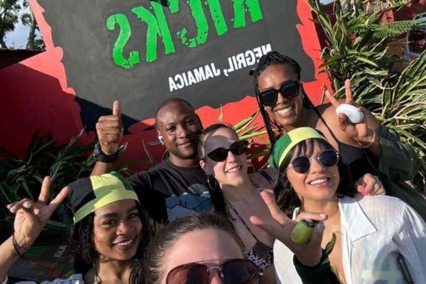 A group of people posing in front of a sign with text. 4