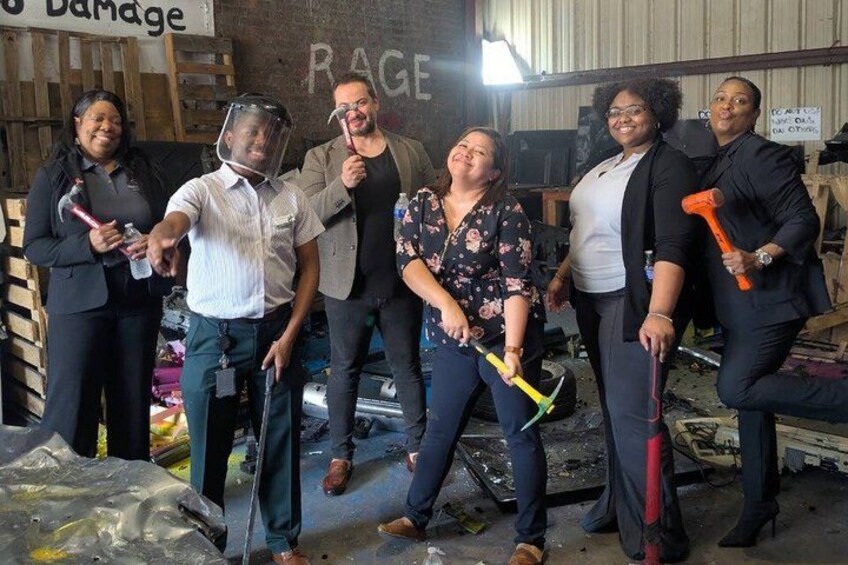 A group of people in a workshop with tools and a sign that reads 'RAGE'. 2