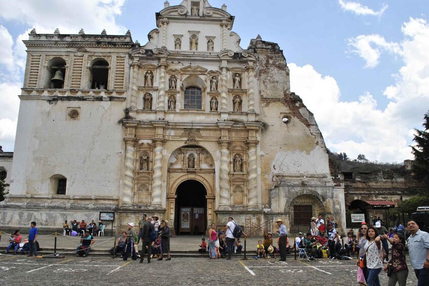 A historic church with a large arched entrance and multiple statues. 3