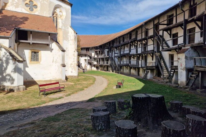 A historical building with a white facade, a red bench, and a pathway leading to a staircase. 1