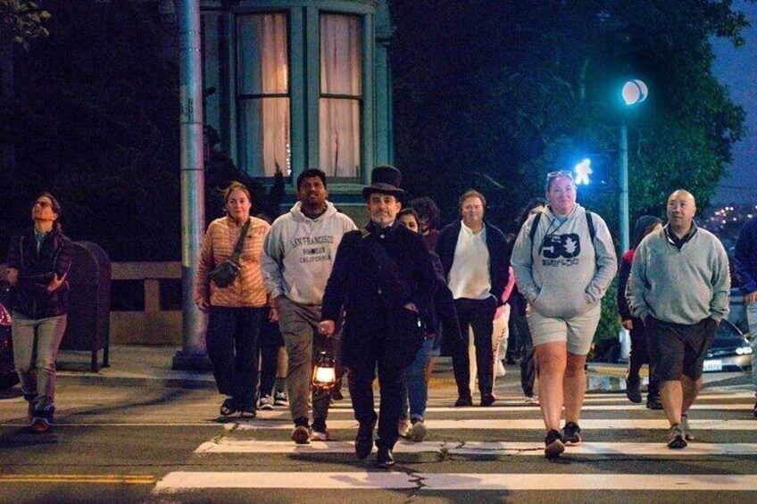 A group of people crossing a street at night. 1