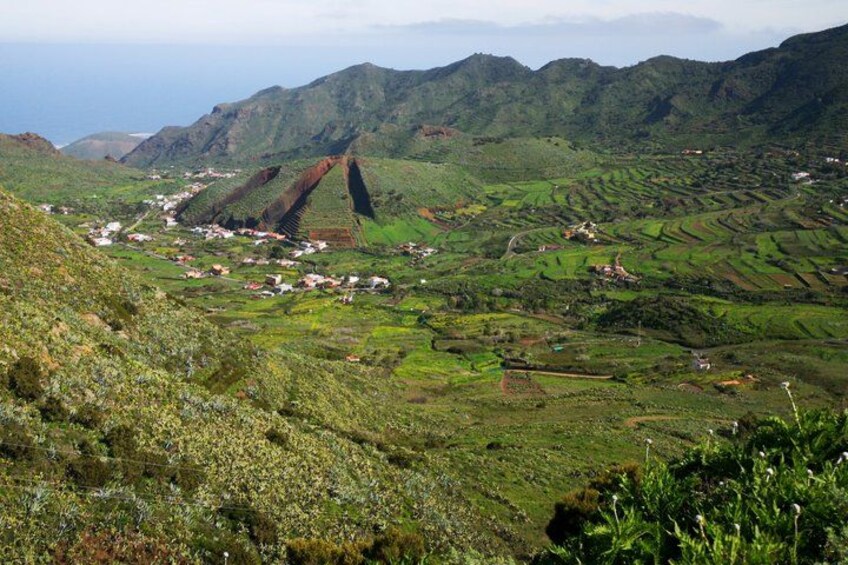 A mountainous landscape with terraced fields and a small village. 3