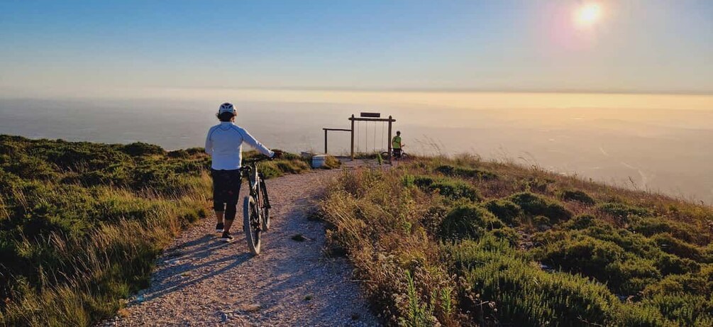 Une personne à vélo sur un chemin de gravier, avec une vue sur l’horizon. 1