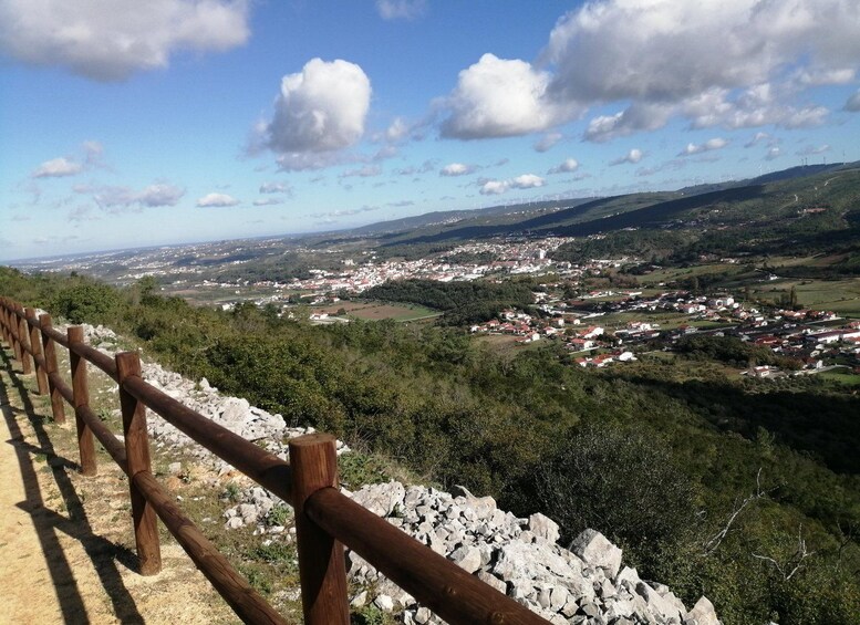 Une vue pittoresque d’une ville nichée dans une vallée, avec une clôture en bois au premier plan. 2