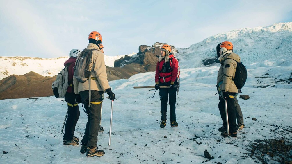 A group of hikers in a snowy mountainous area with rocky terrain and a clear sky. 4
