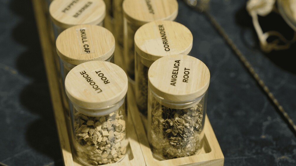 A wooden rack with jars labeled with different spices. 3