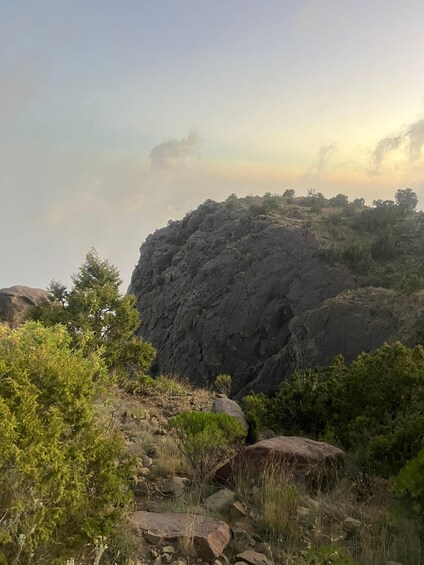 Eine felsige Berglandschaft mit vereinzelter Vegetation und blauem Himmel. 4