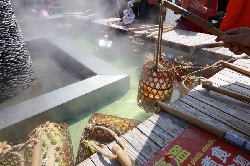 A traditional cooking method with a large woven basket over a steaming pot, wooden planks, and a person handling a rope. 5