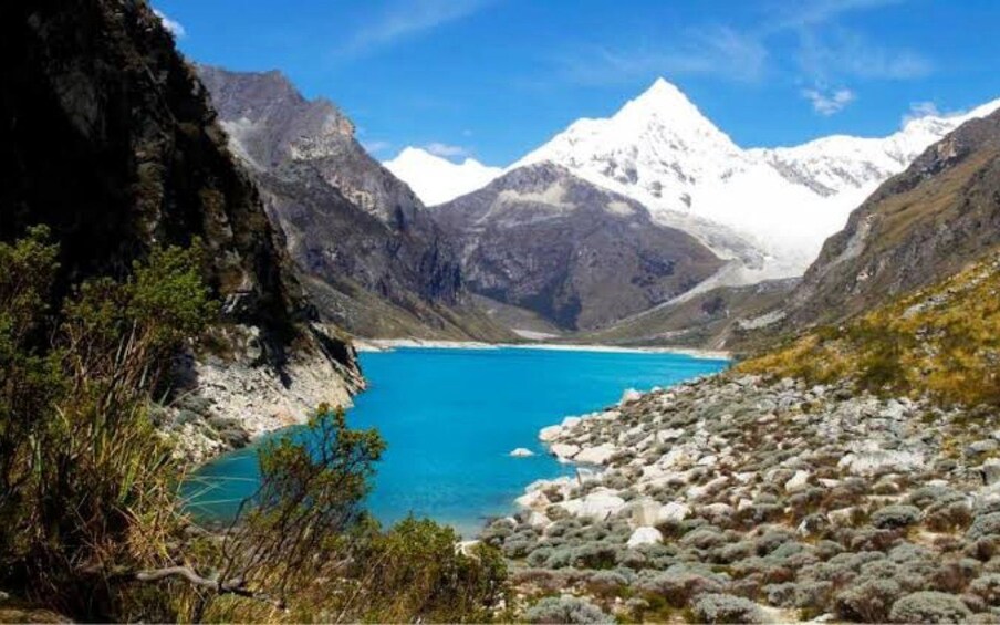 A mountainous landscape with a clear blue lake and snow-capped peaks. 4