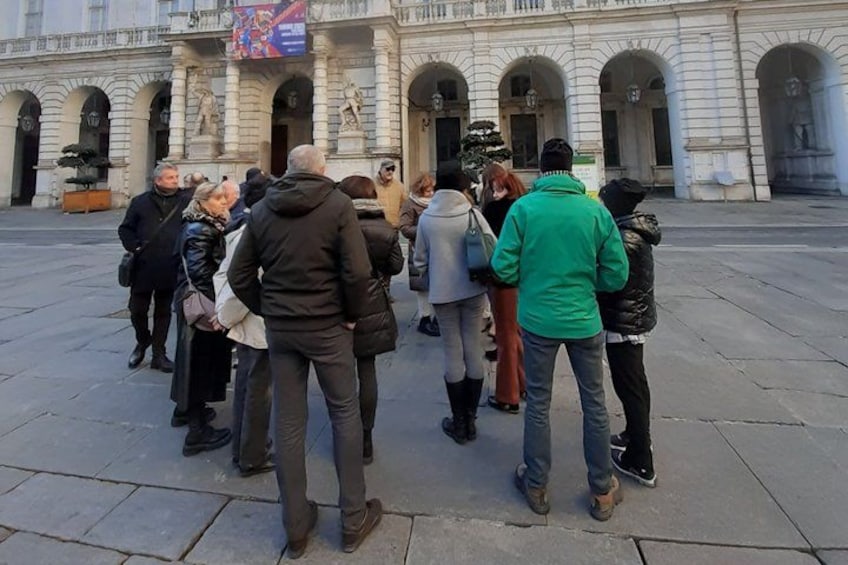 A group of people standing in a plaza with a historic building in the background. 5