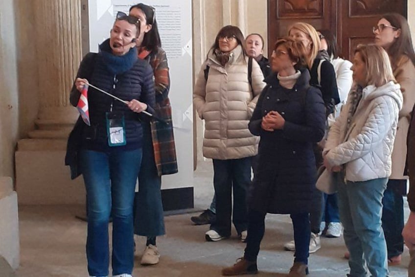 A group of people standing in a hallway with columns. 3
