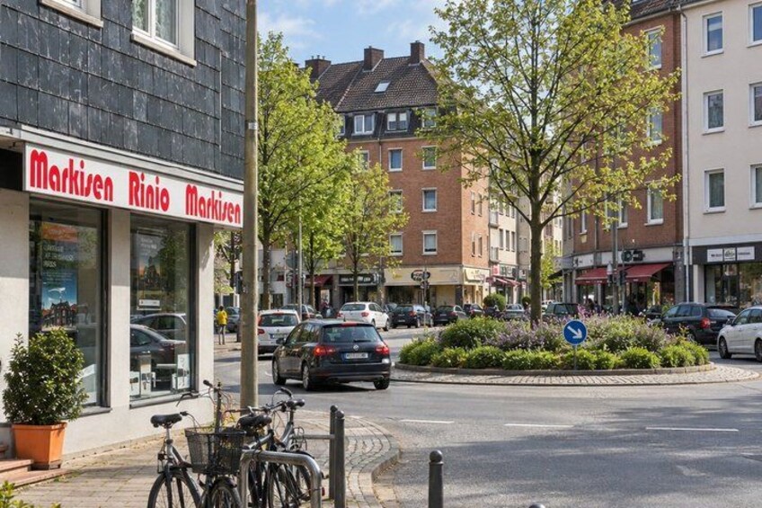 A street with a bicycle parked in front of a shop named 'Markisen Rino Markisen'. 3