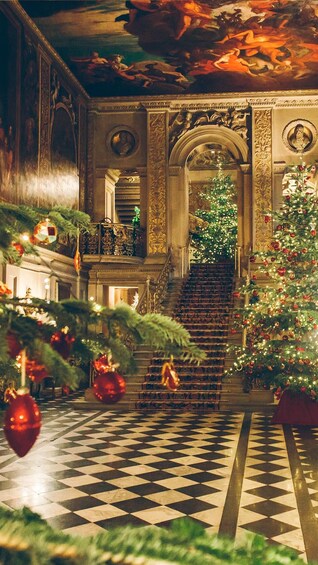 A grand hall with a checkered floor, ornate columns, and a large Christmas tree adorned with ornaments. 3