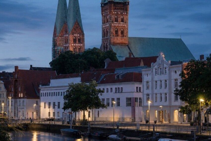 A historic building with a tower and spires, a river, and a bridge. 5
