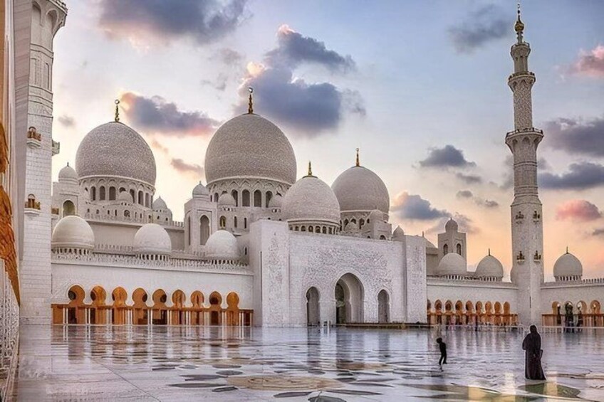 A large white mosque with multiple domes and a tall minaret. 1