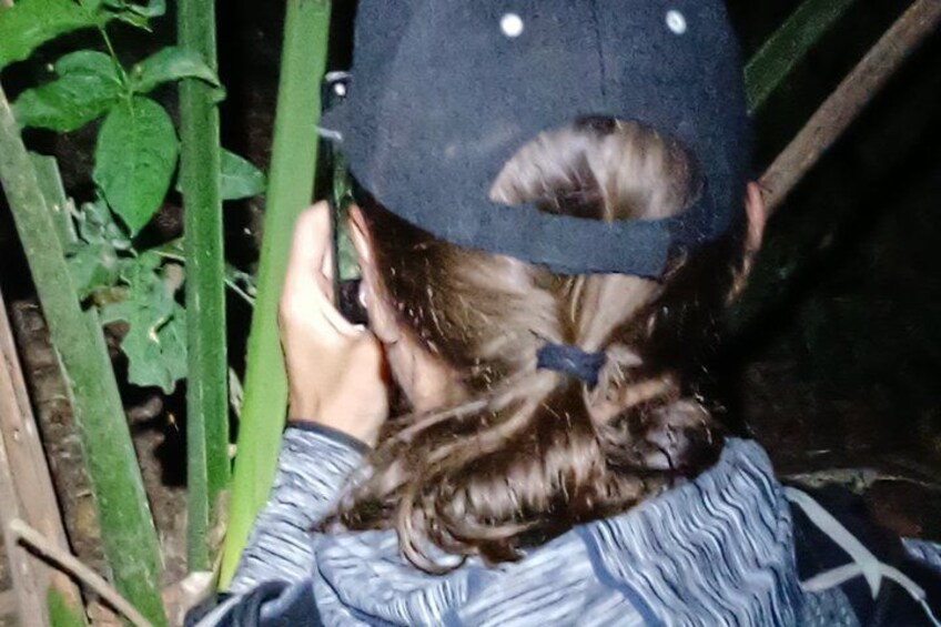 A person wearing a cap and a patterned shirt, holding a phone. 4